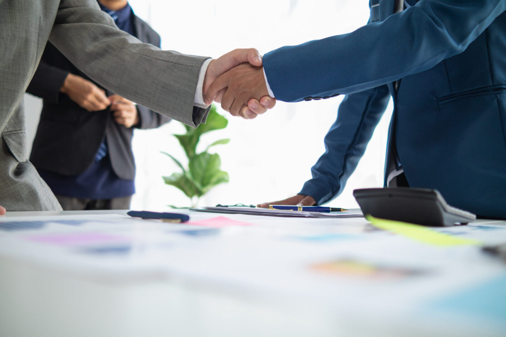 Business partners shaking hands over documents