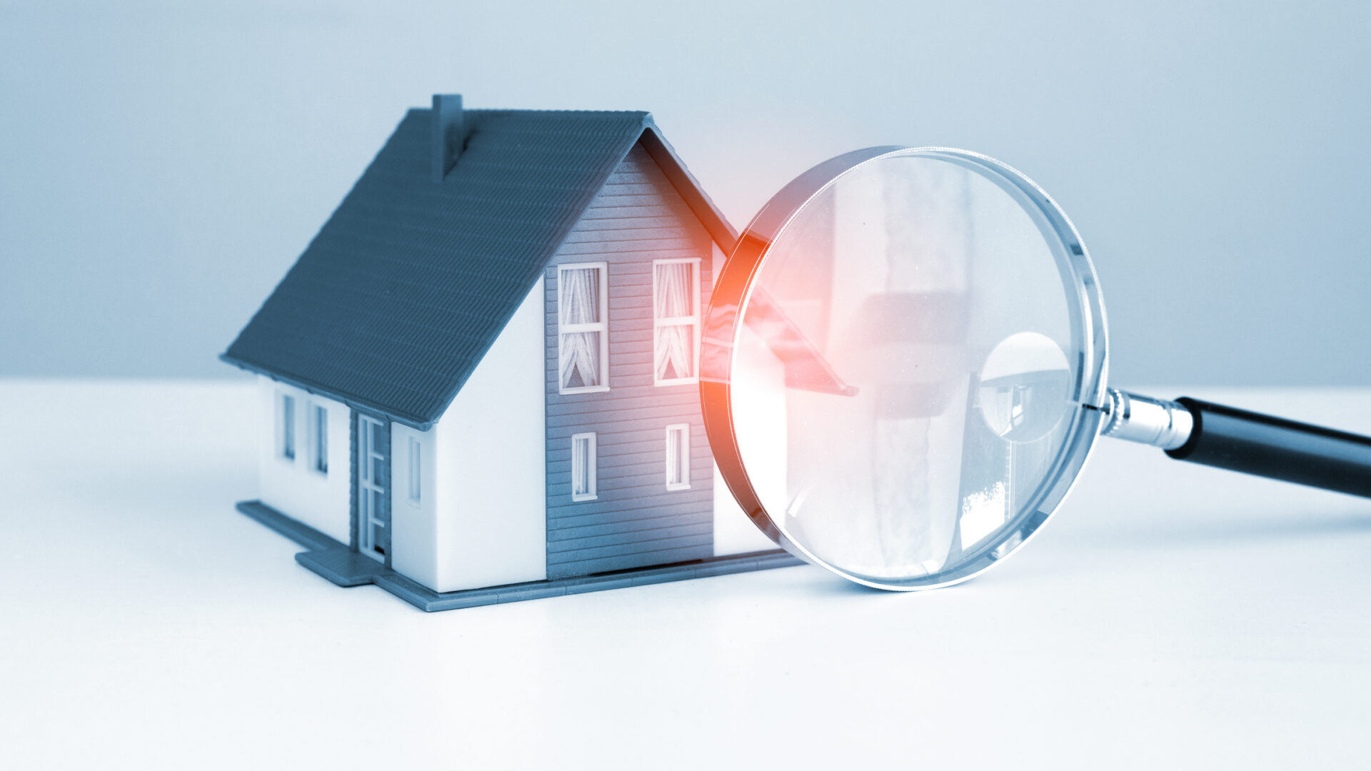 Model house with magnifying glass