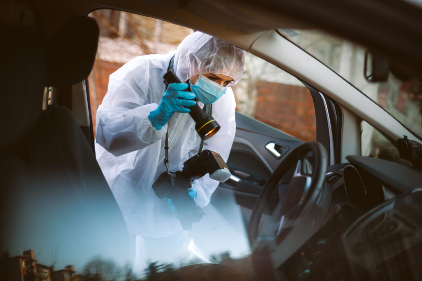 Crime scene investigator inspecting vehicle