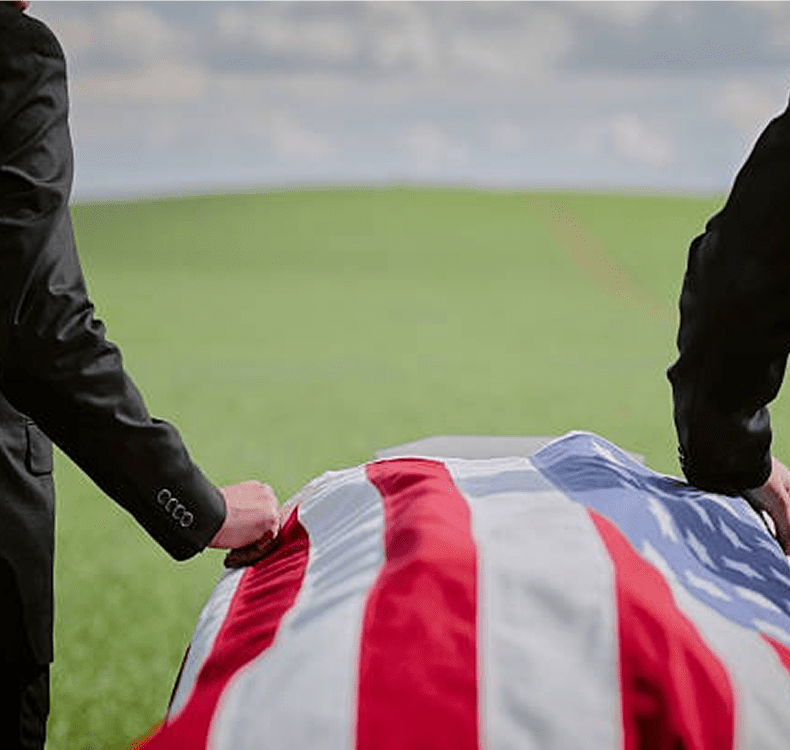 Pallbearers carrying American flag-draped casket