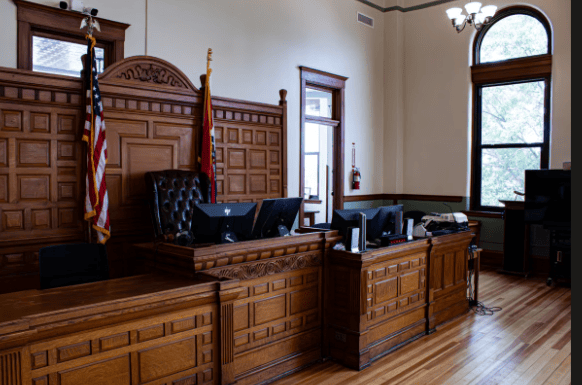 Empty ornate wooden courtroom with judge's bench