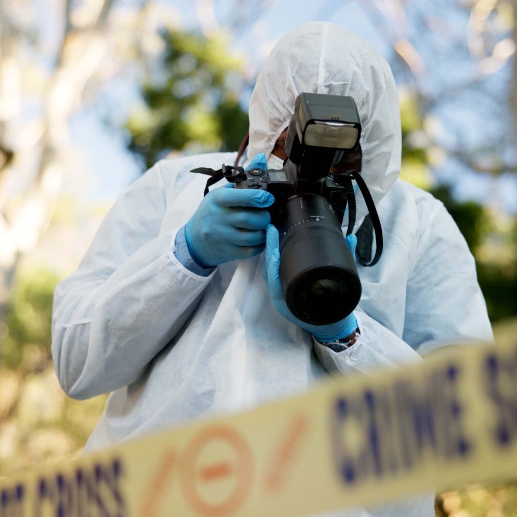 Investigator photographing evidence outdoors